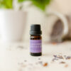 Image of 10 ml bottle of Lavender Essential Oil on white table with green plant in background