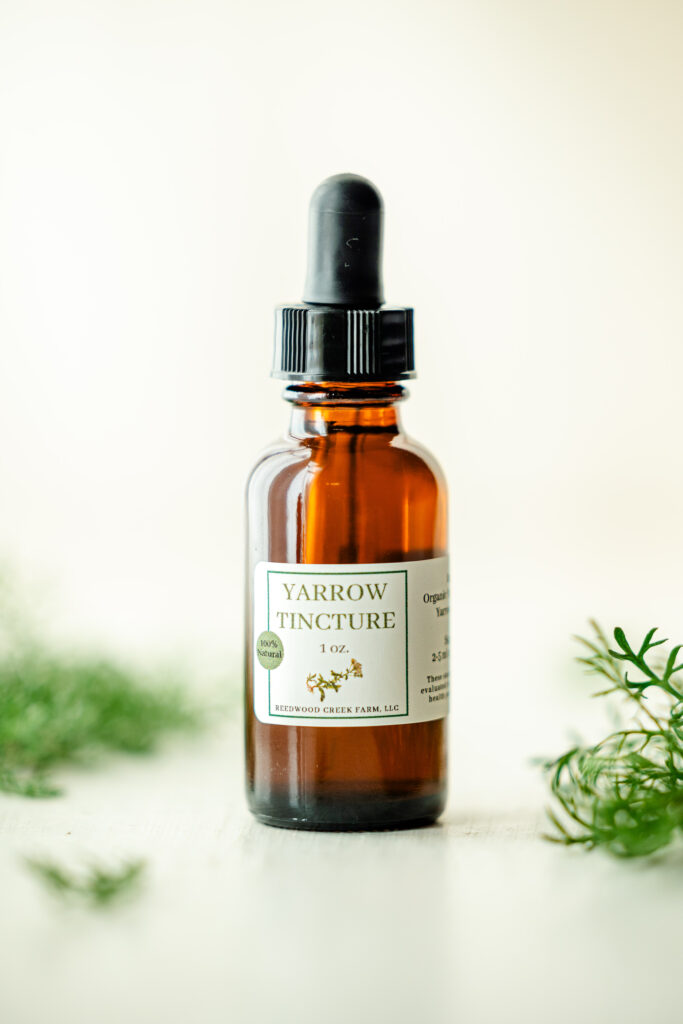 Amber tincture bottle among herbs with white background