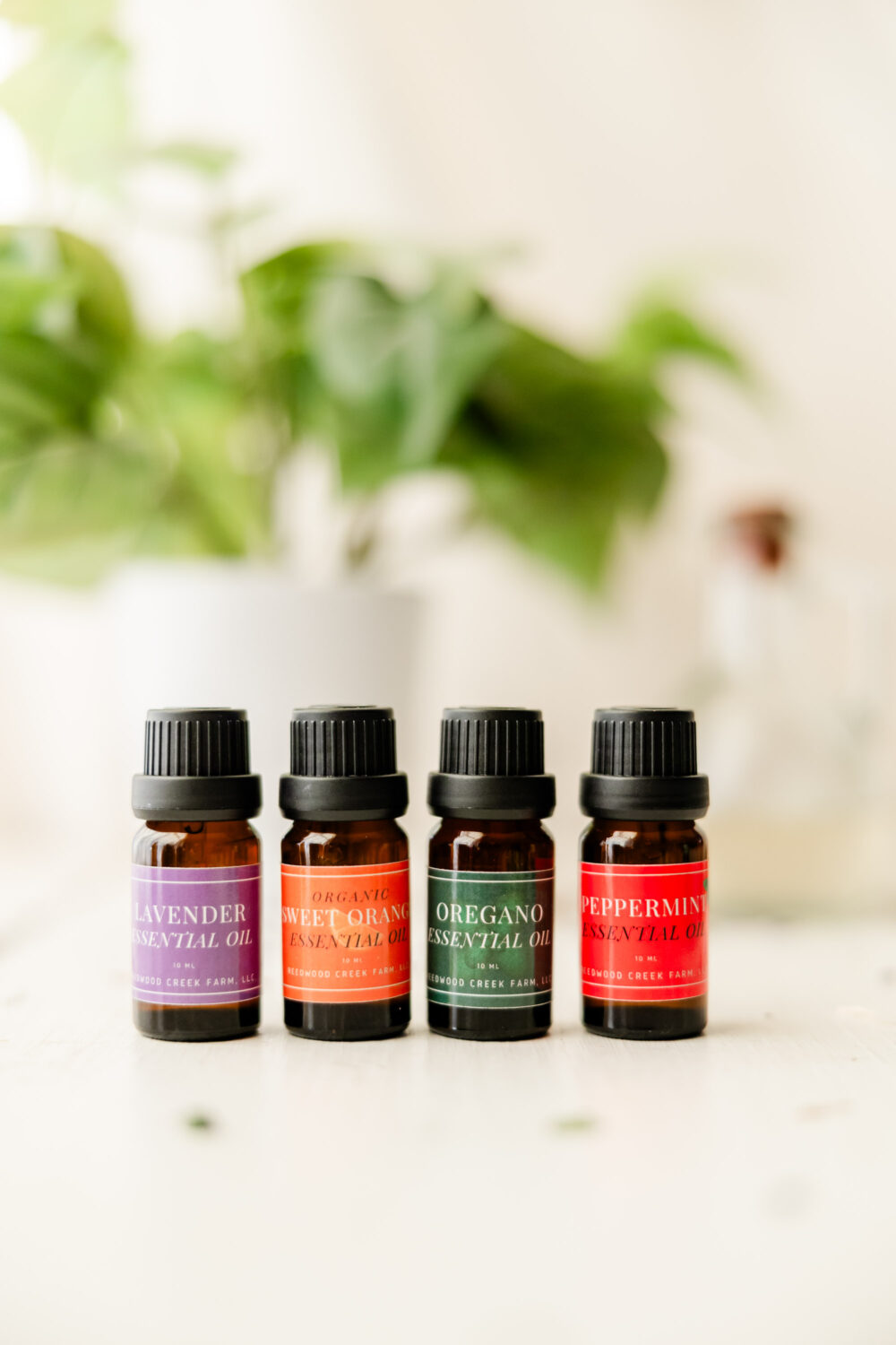 Image of Lavender essential oil, Organic Sweet Orange Essential Oil, Oregano Essential Oil, Peppermint Essential Oil on white table