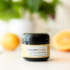 Image of Citrus Tallow Balm in Black Jar on White Table with Lemons and oranges in Background