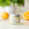 Image of Citrus Tallow Balm in Glass Jar on White Table with Lemons and oranges in Background
